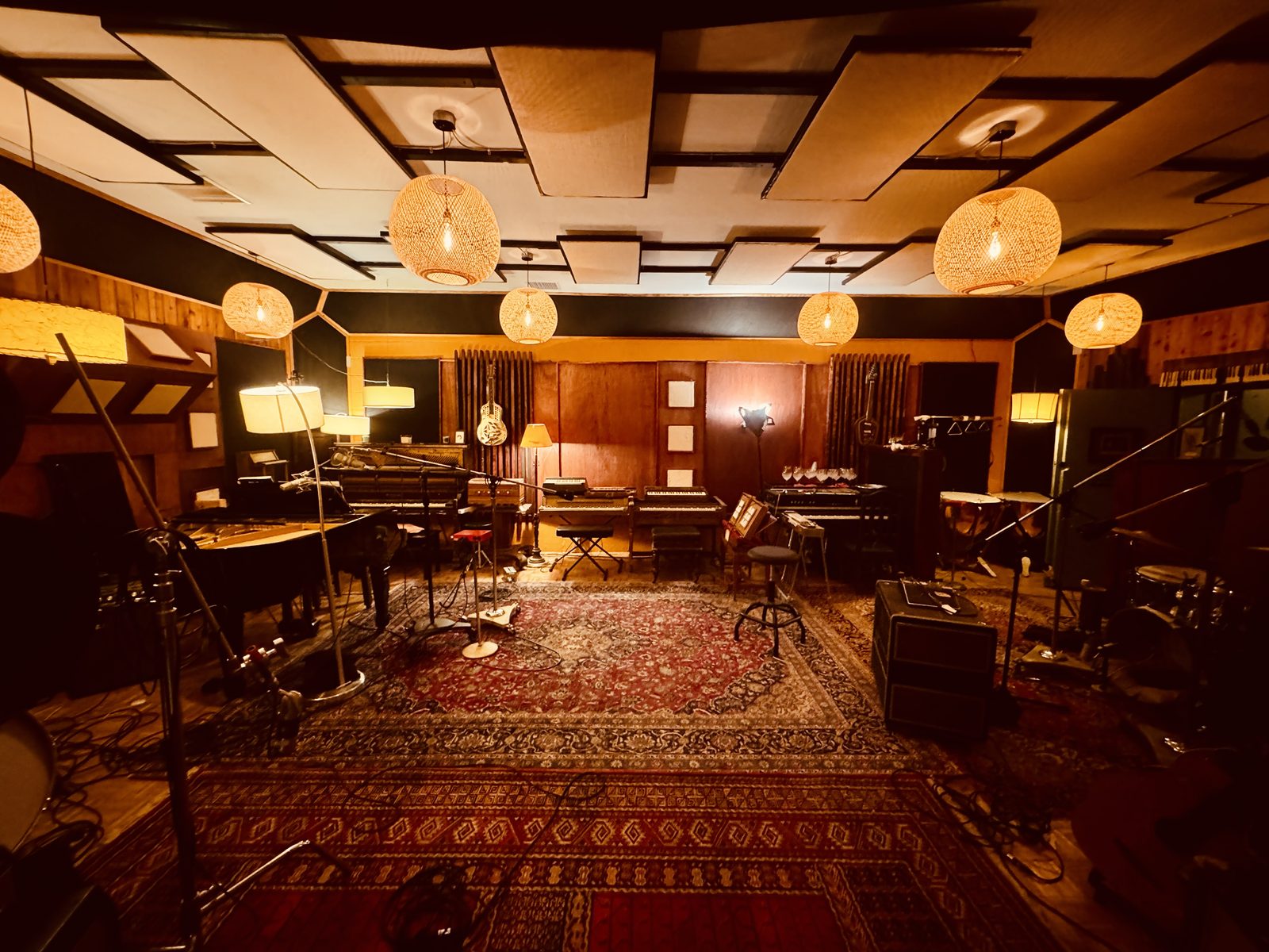 DRP live room — warm wood paneling, red Persian rug, and hanging paper lanterns over the tracking floor